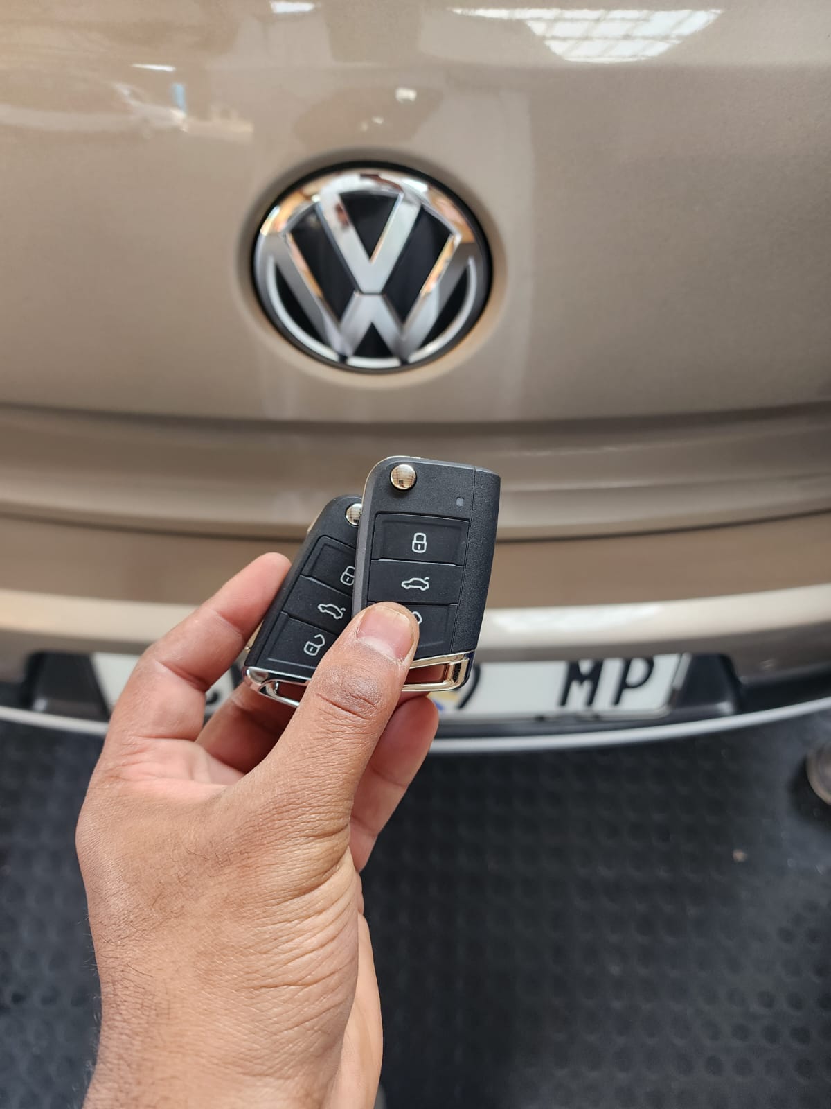 VW remote key fob held in front of Volkswagen badge - Autokey Coding Potchefstroom